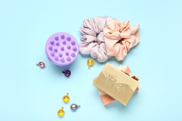 Hair scalp massager with capsules, shampoo bars and scrunchy on blue background