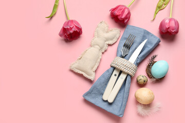 Cutlery for table setting with Easter eggs and beautiful tulips on pink background