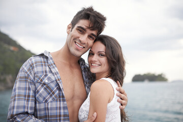 Portrait, smile and couple at ocean on vacation, holiday or travel together outdoor in Italy. Face, man and happy woman at sea for adventure, care and connection in summer by beach in nature for love