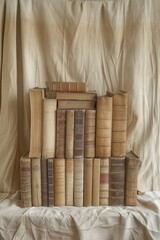 Vintage book display on a warm beige symmetrical muslin backdrop creates a nostalgic, softly focused ambiance.