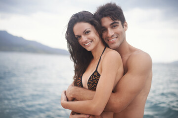 Portrait, smile and couple at ocean for travel, vacation and holiday together outdoor. Face, man and happy woman at sea for adventure, embrace and connection in summer by water in nature for love