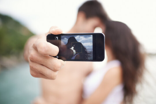 Couple, phone screen and selfie on beach, travel and love on honeymoon vacation. Happy man, woman and cellphone picture for holiday memories, social media and adventure overseas to seaside Bali