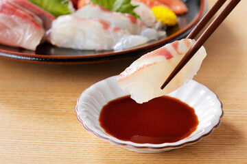 鯛の刺身を箸で持ち上げる