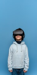 Hispanic or Mediterranean Kid Boy Wearing VR Headset, Enjoying Virtual Reality Experience on Blue Background with Studio Lighting. Vertical Photo Portrait (1:2) with Empty Copy Space