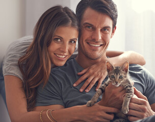 Couple, kitten and portrait in home on sofa with hug for love, bonding or care for pet in living...