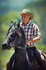 Cowboy, nature and man riding horse with saddle on field in countryside for equestrian or training....