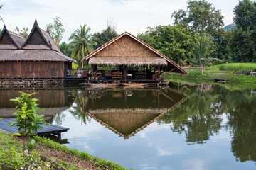 Fototapeta na wymiar Traditional wooden thai house by canal with wood boat