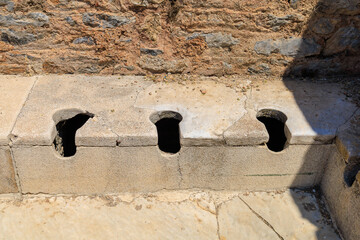 Antique Roman public toilet in the city of Ephesus. Background with selective focus and copy space