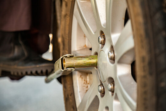 Close up of person changing a flat tyre unscrewing wheel nuts