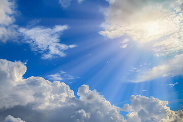 God blessing. Beautiful radiant sunlight in sunshine day. White soft and fluffy clouds on blue sky...