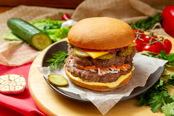 Burger, Sandwich with two meat patties, cheese, cucumber and sauce. Fast food.