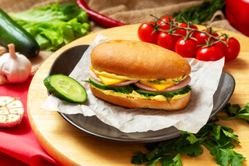 Sandwich with ham, fresh cucumber, cheese and sauce. Fast food.