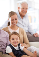 Obraz premium Girl, child and family with happiness on sofa for healthy development, security or comfort in apartment. Face, mother and grandfather with kid, smile and bonding for parenting and love in house