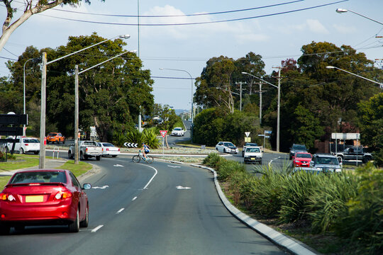 Cars and cyclist approaching a large roundabout in heavy traffic