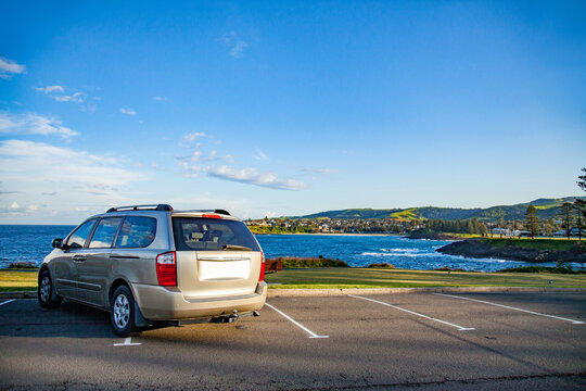 Car parked over the lines in coastal car park with large sky