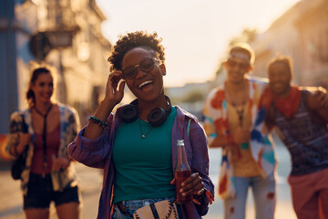 Cheerful black woman having fun while going with friends on summer music festival.