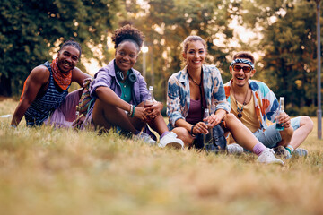 Multiracial group of festival goers in park during summer looking at camera.