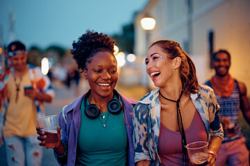 Young happy women having fun on music concert in summer.