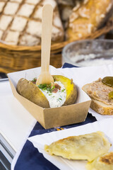 Potato with cheese on market stall. Traditional, classic Poznań dish
