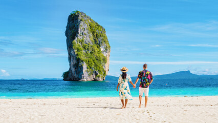 Diverse couple of Asian women and European men walking on the tropical beach of Koh Poda Island...