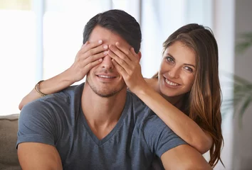 Gardinen Portrait, smile and couple with surprise in home, love and happy people bonding together for romance. Face, man and woman covering eyes for connection, care and healthy relationship in living room © peopleimages.com