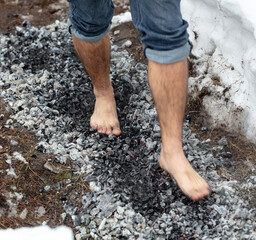 Legs of a man walking on burning coals