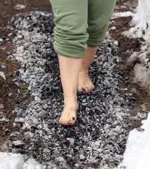Legs of a girl walking on burning coals