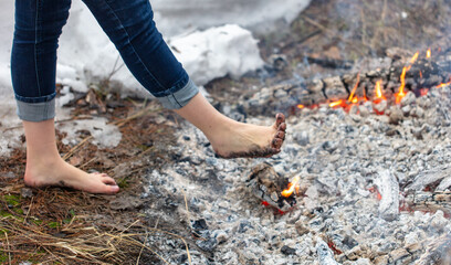 Legs of a girl walking on burning coals - 744420890