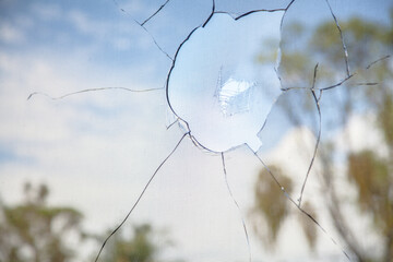 Vandalized window of building, smashed broken glass