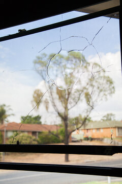 Vandalized window of building, smashed broken glass