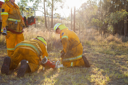Volunteer firefighters in NSW rural fire brigade attaching fire hydrant and hose