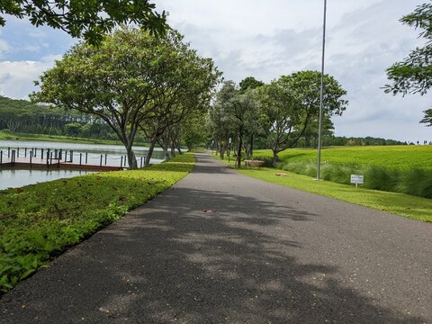 Mini jogging park on the Semarang Central Java with lake, cloudy vibes and blue sky. The photo is suitable for park background, relax and enjoy place content media.