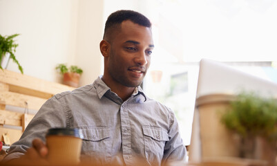 Fototapeta premium Black man, smile and cafe with laptop for coffee, working and sitting indoors. Freelancer, internet and connectivity for research project, professional and remote work in restaurant with technology