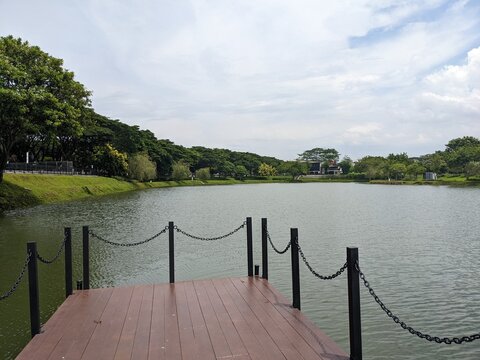 Landscape lake, track and wooden dock on BSB Semarang, Central Java. The photo is suitable to use for traveler content media, holiday background and garden poster.