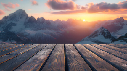 A wooden floor looks out over a stunning mountain range at sunset.