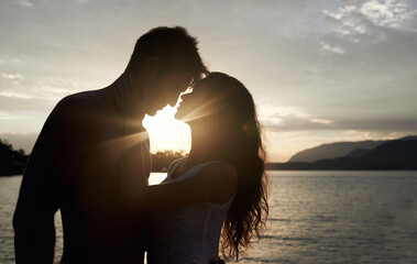 Silhouette, couple and love by ocean at sunset, vacation or travel together in summer. Man, woman...