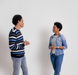 Young boyfriend and girlfriend with afro hairstyle discussing while standing on white background