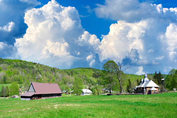 View of village Olchowiec (Low Beskids, Poland) in springtime. Dramatic sky.