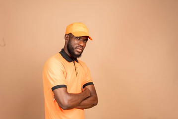 handsome deliveryman employee in orange cap looking focused