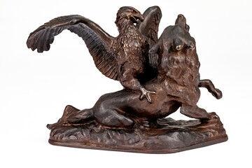 A purchased (consumer) figurine of an eagle on a wolf made of cast iron in close-up on a white...