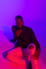 Studio portrait of a young man with on blue-pink background.