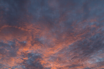 Naklejka na ściany i meble Dramatic sunset with vibrant clouds lit by a sun