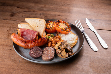 breakfast dish english irish uk with lots of protein sweet beans sausage bacon egg mushrooms