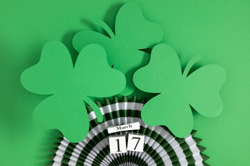 Block calendar for St Patrick's Day, March 17 ,with green clover leaf and decorations on green...