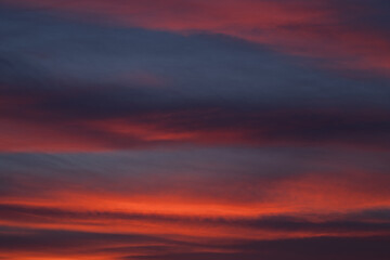 Naklejka na ściany i meble Dramatic sunset with vibrant clouds lit by a sun