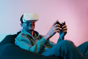 A man with a VR headset laughs joyfully, holding a controller, immersed in a virtual game world