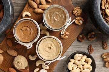 Making nut butters from different nuts. Fat lay composition on wooden table