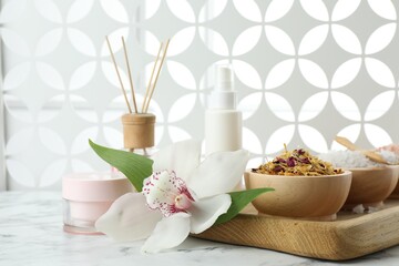 Fototapeta na wymiar Beautiful composition with different spa products and orchid on white marble table