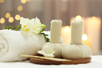 Beautiful composition with different spa products and flowers on white towel against blurred background, closeup