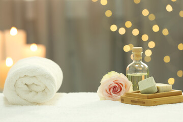 Obraz na płótnie Canvas Beautiful composition with different spa products and rose on white towel against blurred lights